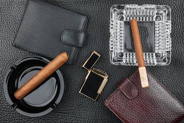istock Golden lighter with cigar and purse lying on a black 508661172