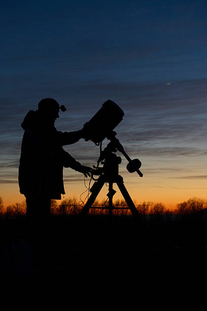 Amateur astronomer with his telescope Amateur astronomer checking his telescope before observing the night sky. astronomer photos stock pictures, royalty-free photos & images