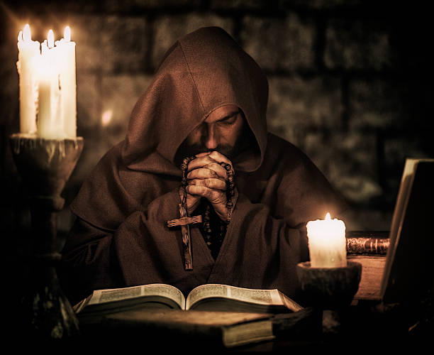 Monk praying Monk praying inside monastery ancient christianity stock pictures, royalty-free photos & images