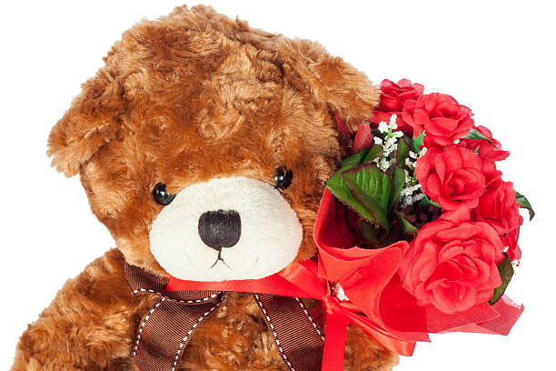 istock Teddy bear holding red roses valentines day 508668492
