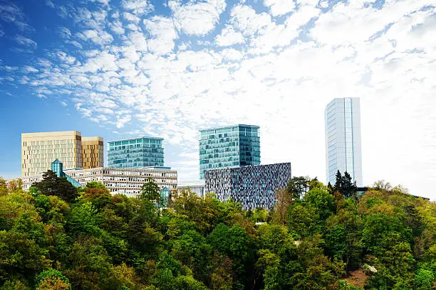 Modern buildings with beautiful sky and clouds in Luxembourg surrounded by forest