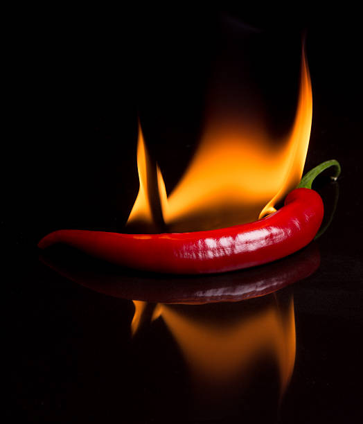 istock hot pepper - chili and flames on a black background 508670041