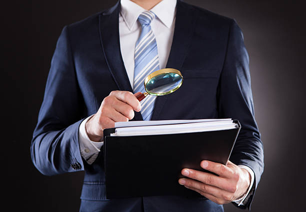 istock Businessman Examining Documents With Magnifying Glass 508671105