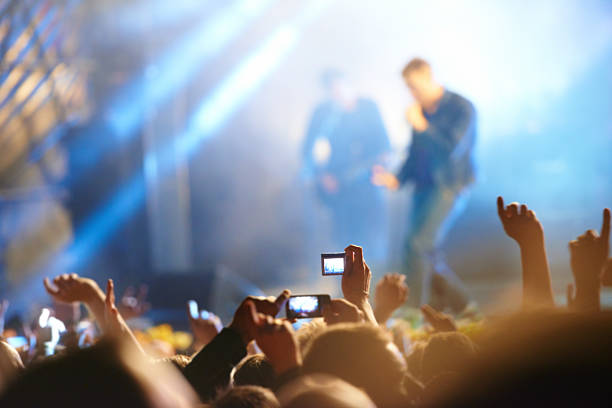 Capture the craziness! Rear view of a crowd of people watching their band perform beneath the strobe lights on stage singer back stock pictures, royalty-free photos & images