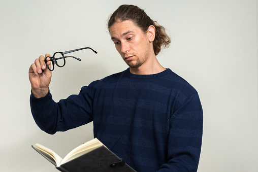 Studio shot of long haired man reading book