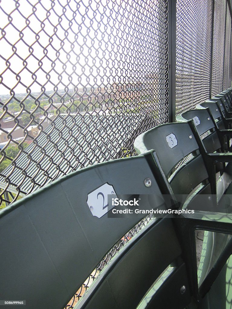 Back row of bleacher seats in ballpark The last row of stadium seats in a ballpark with a chain link fence in the background Baseball - Sport Stock Photo