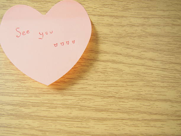 istock See you tag on post it, heart shape, wood background 508700834