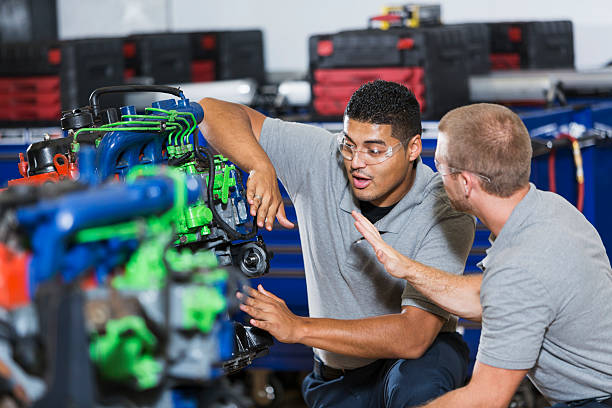 istock Two multi-racial men in auto mechanic school with engine 508701004