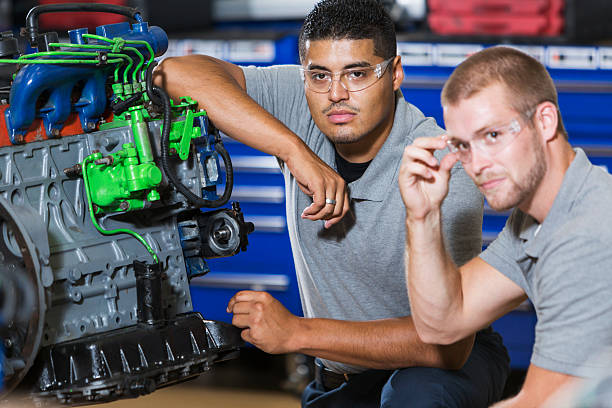 istock Two multi-racial men in auto mechanic school with engine 508701026