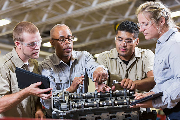 klasa zawodowe, wiedzę do naprawy gasoline engine - trainee auto repair shop computer manual worker zdjęcia i obrazy z banku zdjęć