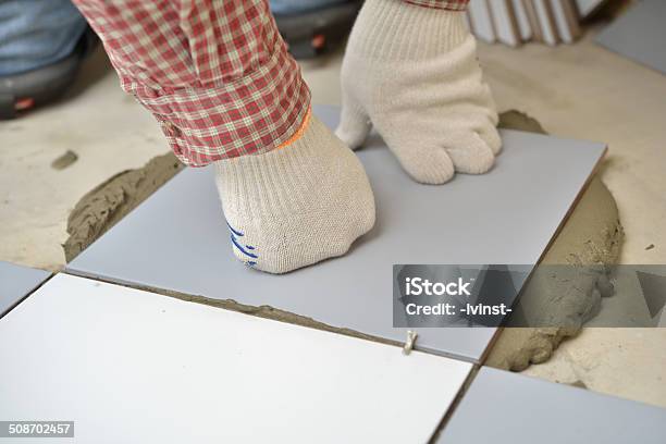 Installing Ceramic Tiles On A Floor Stock Photo - Download Image Now - Kneepad, Occupation, Working