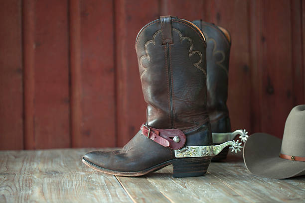 istock Cowboy boots, spurs and hat on old wood background 508704741