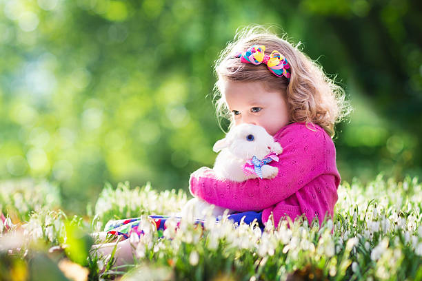 istock Little girl playing with bunny on Easter egg hunt 508705660