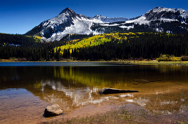 Colorado snow mountains fall colors reflecting in lake stock photo