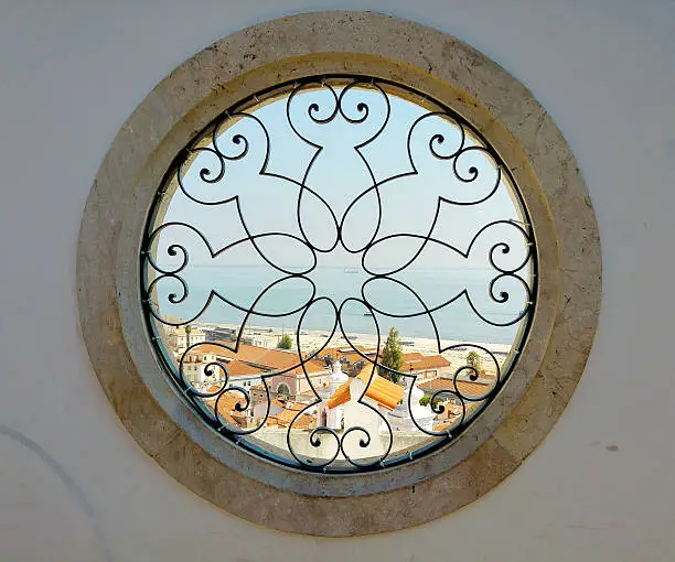 round art window with view on the harbor and old city of lissabon in Portugal