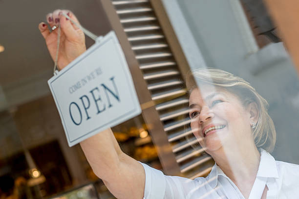 istock Woman working at the bakery hanging an open sign 508710708