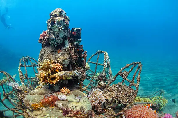 Photo of Underwater Buddha statue with diving snorkeler on the background0122