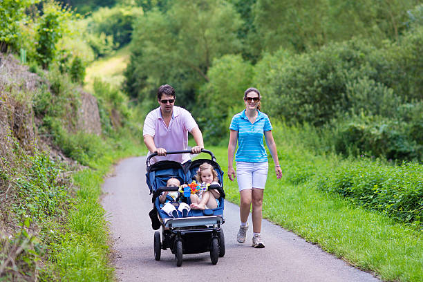 eltern mit kinderwagen - gehen sportdisziplin stock-fotos und bilder