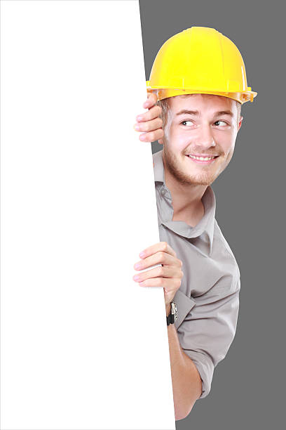 istock Young man holding blank billboard wearing hard hat 508731801