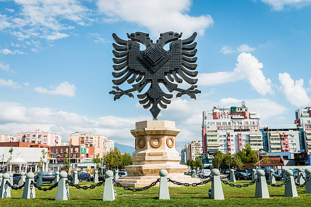 Albania Coat of Arms Emblem Tirana City Giant Coat of Arms of Albania Emblem Statue in a street roundabout in the city center of Tirana under blue summer sky with fluffy cloudscape, Tirana, Capital of Albania, South Eastern Europe. tirana photos stock pictures, royalty-free photos & images