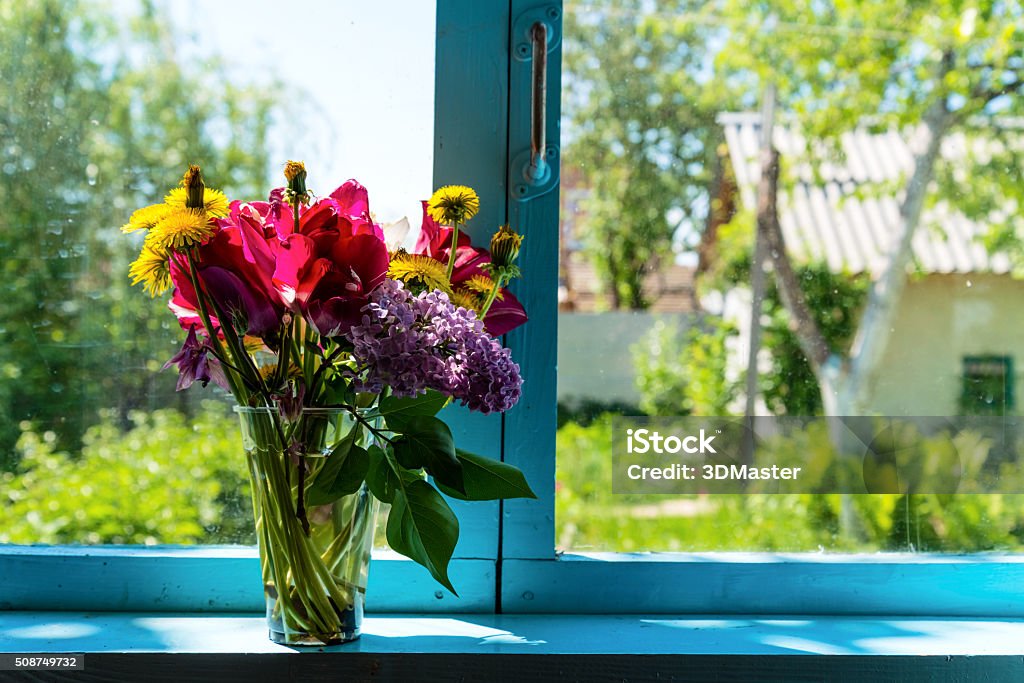 Flowers on the window Bouquet of beautiful flowers on the blue window against garden Blue Stock Photo