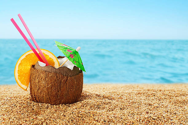 kokos-cocktail am strand. - drink umbrella stock-fotos und bilder