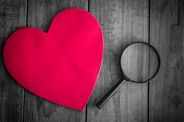 istock Read heart paper with magnifying glass on grunge wood table 508752192