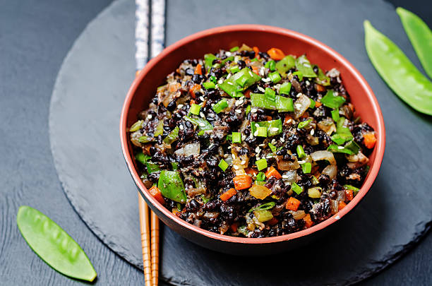 istock Black rice with snap peas and vegetables on a black 508757756