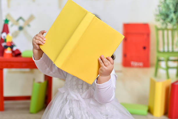 istock Girl hiding with book 508757928