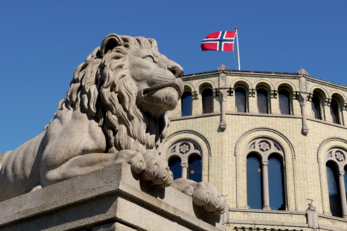 lion statue and the norwegian parliament in oslo