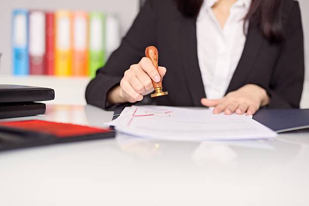 istock Close up on woman's notary public hand stamping the document 508758632