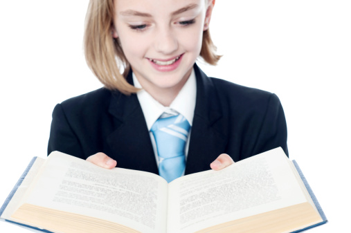 Beautiful smiling girl reading a open book