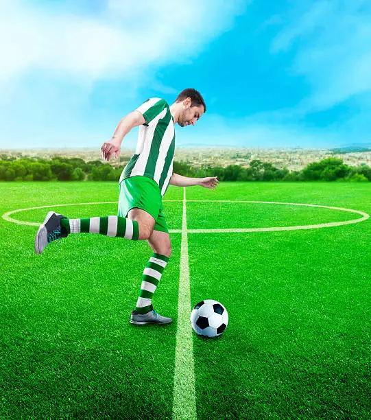 Football-player kicking the ball on the football ground