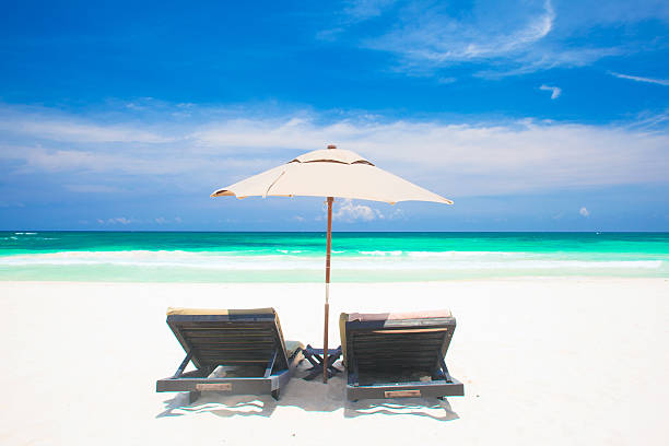 istock two beach chairs and umbrella on sand beach. Holidays 508761500