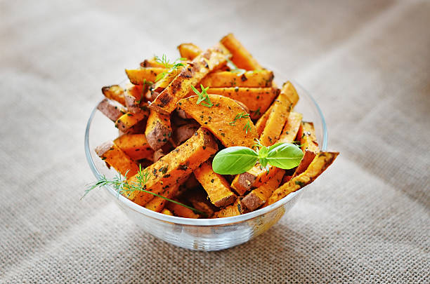 Sweet potato baked Baked sweet potato corners in a bowl sweet potato french fries stock pictures, royalty-free photos & images