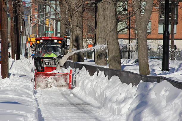 Hoboken, New Jersey, USA - January 24, 2016: On this photo you could see a snowblower machine cleaning a pavement from snow at Hudson street in Hoboken city, New Jersey after blizzard Jonas.