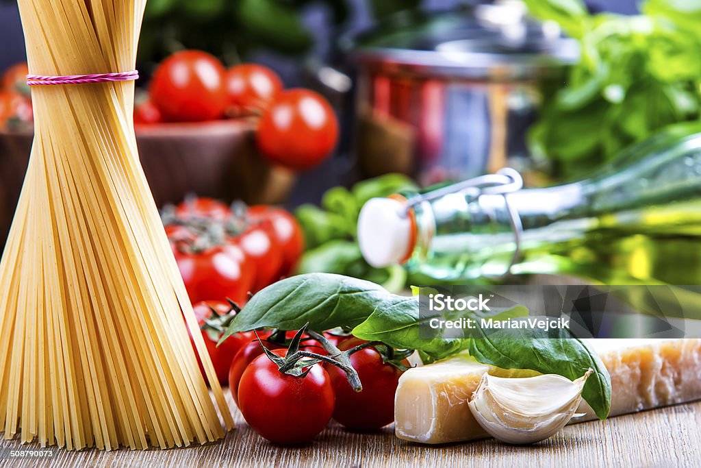 Basil leaves garlic pene,spghetti and cherry tomatoes Some ingredients of Italian cuisine.Basil leaves garlic pene and cherry tomatoes Italian Food Stock Photo