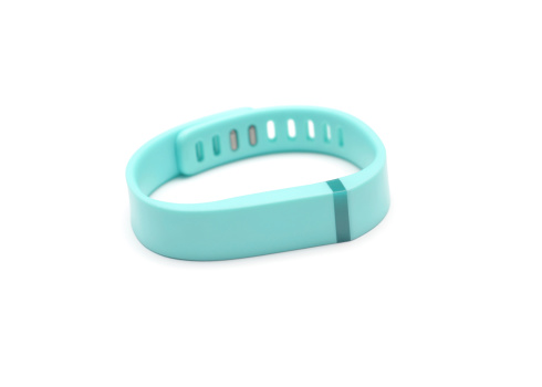 Vancouver, BC, Canada -- August 24, 2014:Close up of a Fitbit Flex on a white background with shadows.  A Fitbit in a wireless activity and sleep monitor wristband that promotes activity and wellness.