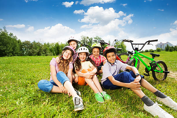 istock Happy kids in helmets sit on grass and smile 508791409