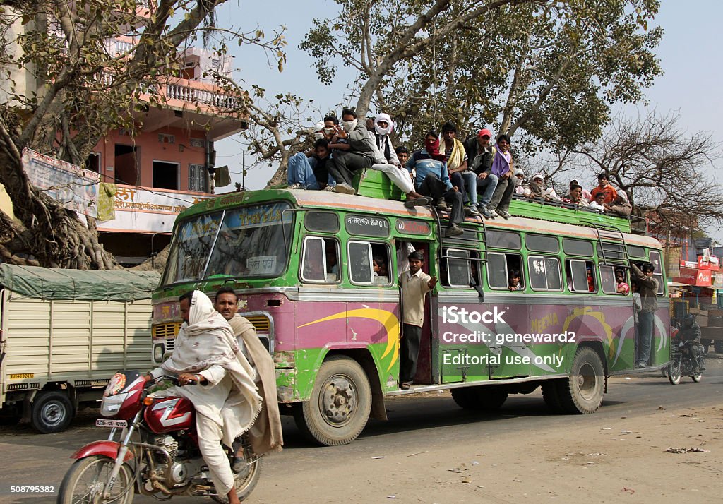 people ride on top of a bus in Rajasthan Rajasthan, India.  January 16, 2012.  People ride on top of a crowded bus. Bus Stock Photo