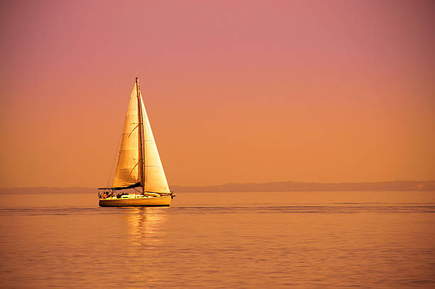 solitario barca a vela - sailboat sunset sailing nautical vessel foto e immagini stock