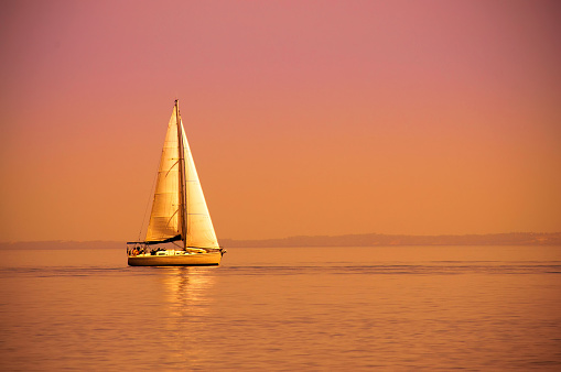 Lonely sail boat at sunset