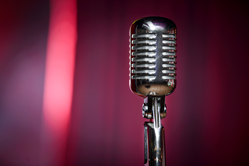 A microphone on stage over a red background