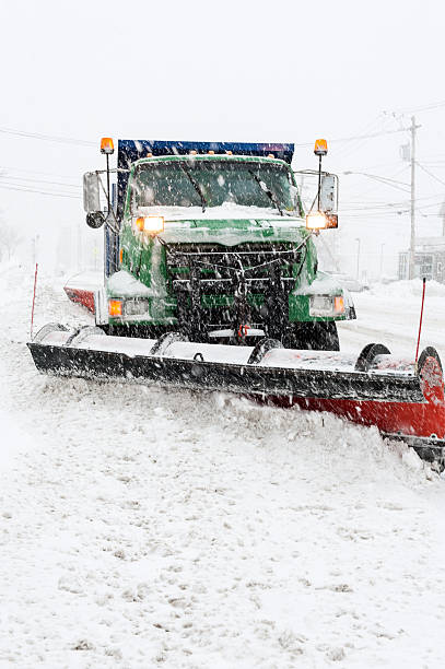 Plow truck clears street after a snow storm stock photo