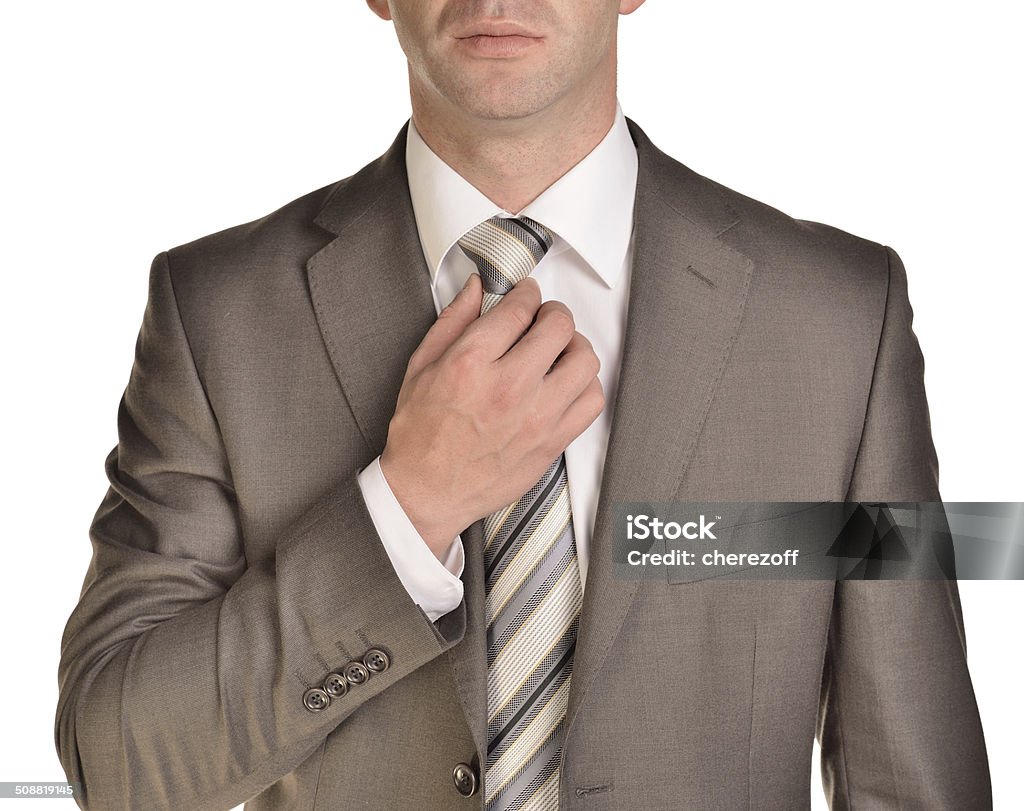 Businessman corrects his tie Businessman corrects his tie. Isolated on white Adjusting Stock Photo