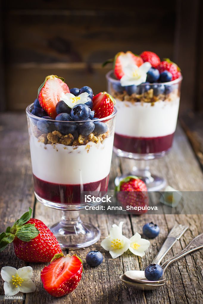 dessert with  berries,  cream cheese, granola  and berries  jam dessert with fresh berries,  cream cheese, granola and berries  jam on rustic background Berry Stock Photo