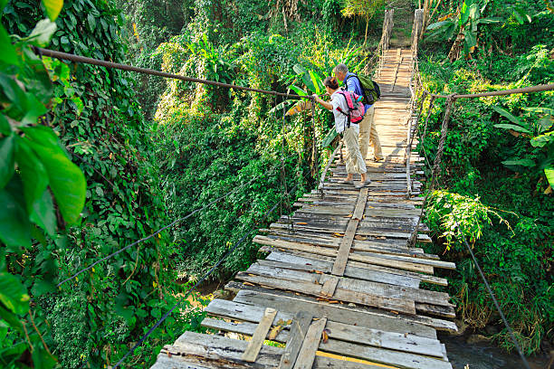 istock Couple with backpack hiking in rainforest jungle 508836440