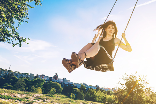 young woman swinging in berlin summer park