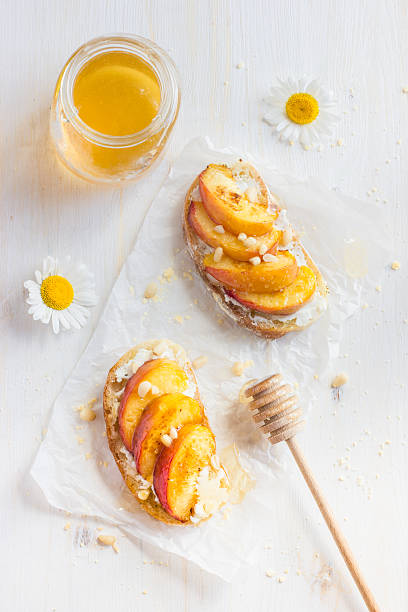 bruschetta with ricotta, grilled peach and honey bruschetta with ricotta, grilled peach and honey, top view crostini stock pictures, royalty-free photos & images