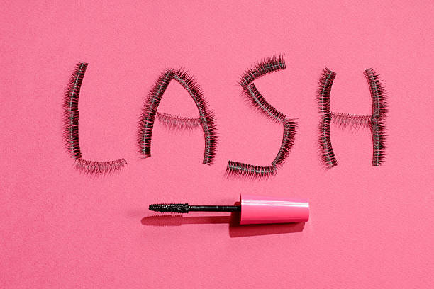 The inscription lash with false eyelashes false eyelashes and mascara on the throw pink background. Top view, there is an empty space. The inscription lash clump eyelashes stock pictures, royalty-free photos & images